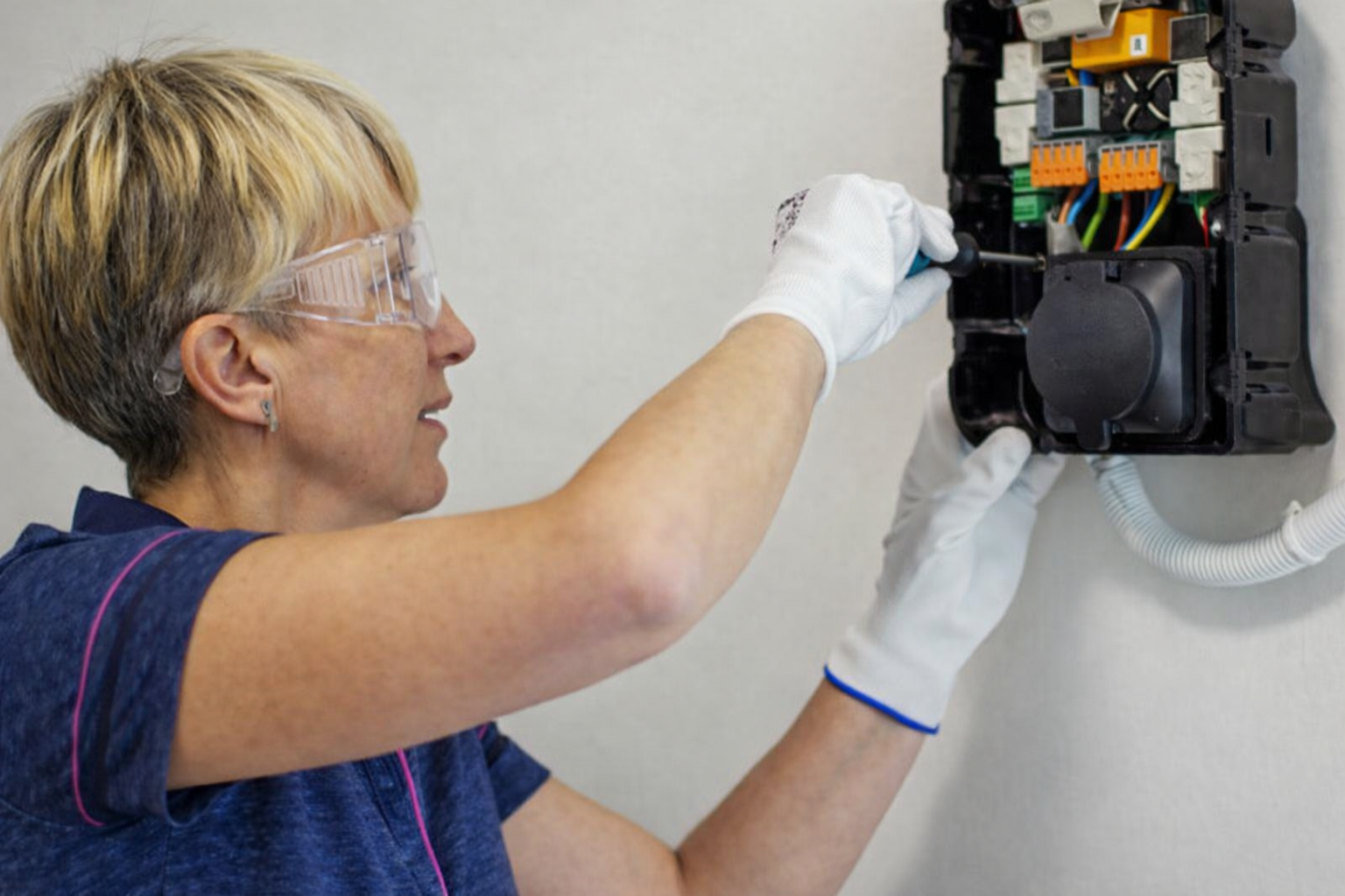 Woman working on electrical panel